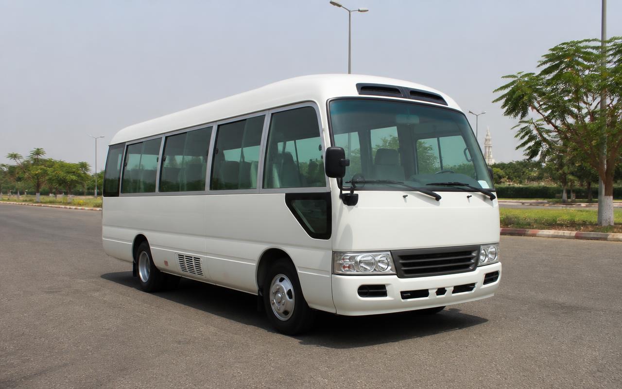 White Toyota Coaster bus parked on a wide road in Abuja in bright daylight