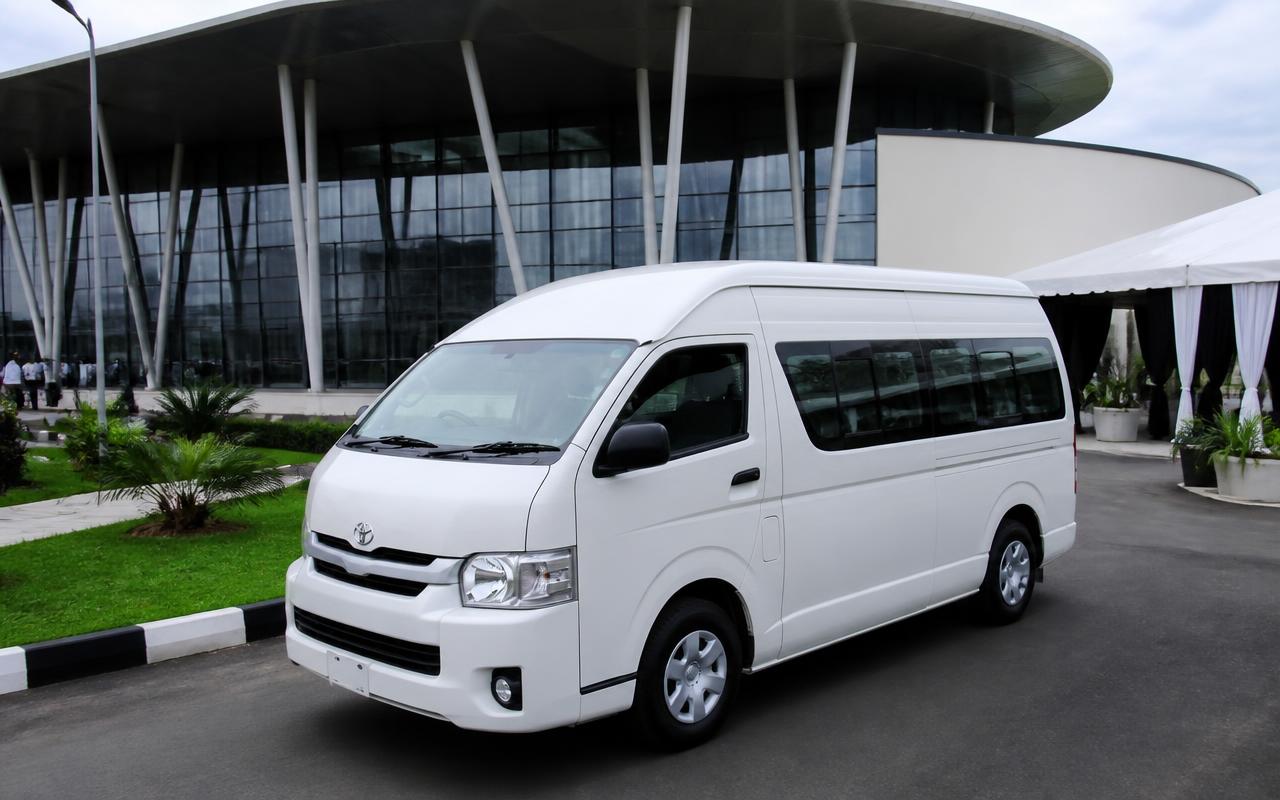 White Toyota Hiace passenger van parked outside a modern event centre in Lagos